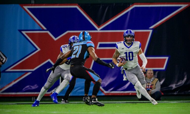 Feb 9, 2020; Arlington, Texas, USA; St. Louis Battlehawks quarterback Jordan Ta'amu (10) tries to elude Dallas Renegades safety Micah Abernathy (21) during the second half in an XFL football game at Globe Life Park. Mandatory Credit: Jerome Miron-USA TODAY Sports